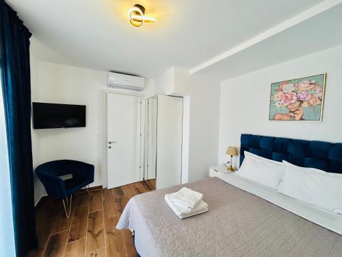 a bedroom with a blue bed and a blue chair at Sani Beverly Hills Luxury Villas in Sani Beach