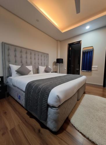 a bedroom with a large bed with a large headboard at Hotel Giri Prime Inn Near Cyber City, Phase 3 Metro in Gurgaon