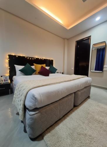 a large bedroom with a large bed with colorful pillows at Hotel Giri Prime Inn Near Cyber City, Phase 3 Metro in Gurgaon