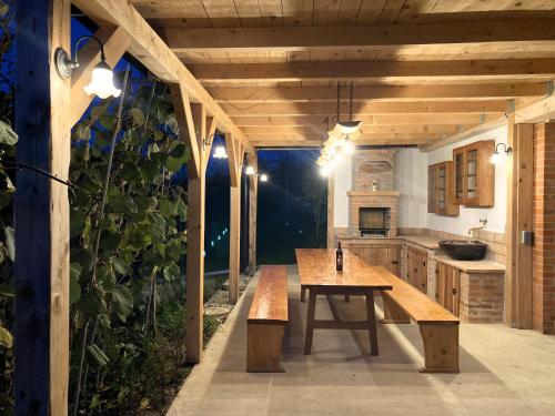 an outdoor kitchen with a wooden table and benches at Papa Franks House in Ptuj