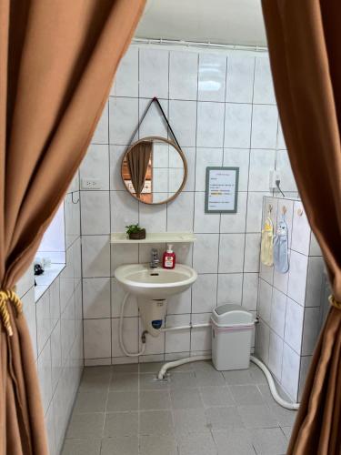 a bathroom with a sink and a mirror at Horn Seaside Homestay in Nangan