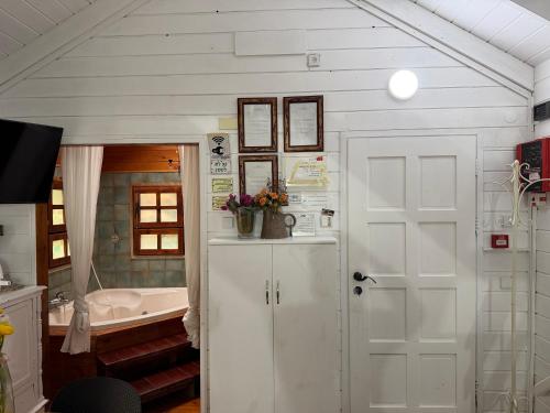 a bathroom with a white door and a tub at בקתות עץ סקנדינביות במטולה in Metulla