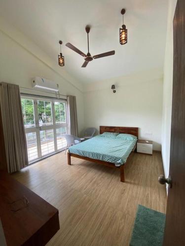 a bedroom with a bed and a ceiling fan at Nirvana Villa Karjat in Dhamni