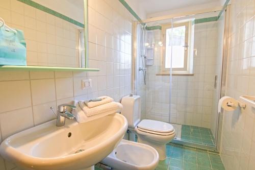 a bathroom with a sink and a toilet and a shower at Villa Ginanneschi - Le Pitte in Capoliveri
