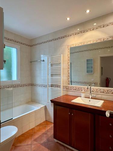a bathroom with a tub and a sink and a toilet at Villa Sa Punta in Cala en Blanes