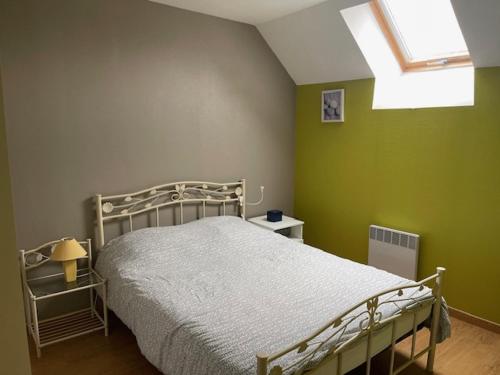a bedroom with a bed with green walls and a window at Chat-Douillet in Veuzain-sur-Loire