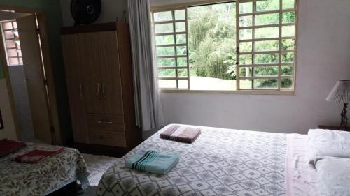 a bedroom with a bed and a window at um pedaço do paraíso in São Roque