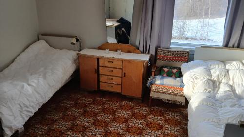 a bedroom with two beds and a dresser and a chair at The house by the waterfall in Breim