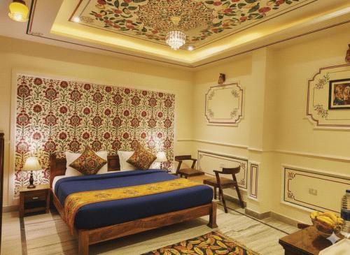 a bedroom with a king sized bed and a ceiling at Hotel The Rajputana Ranthambore in Sawāi Mādhopur