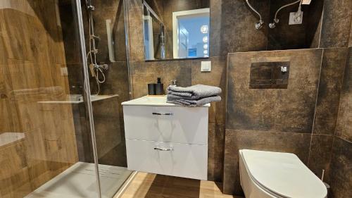 a bathroom with a toilet and a glass shower at Fieldorfa House in Ostrołęka