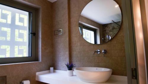 a bathroom with a white sink and a mirror at Cosmos Residences in Vasiliki