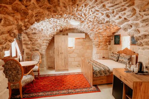 a bedroom with a bed in a stone wall at Kasr-ı Kikan Hotel in Mardin