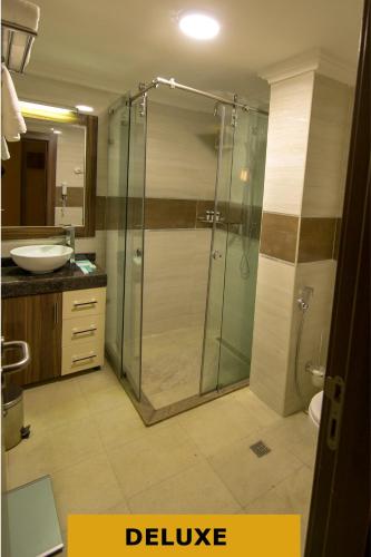 a bathroom with a shower and a sink at Joygate Hotels & Suites in Lagos