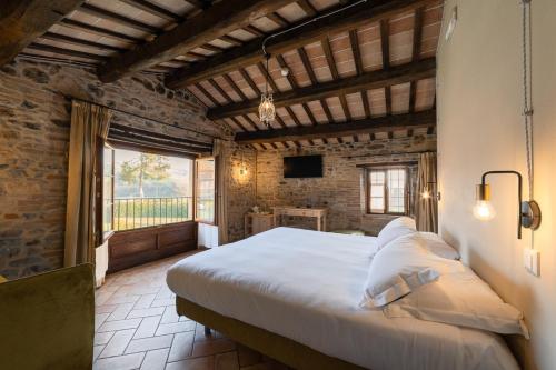 a bedroom with a large bed in a room with a window at Ca' Virginia Country House Wellness in Montecalvo in Foglia