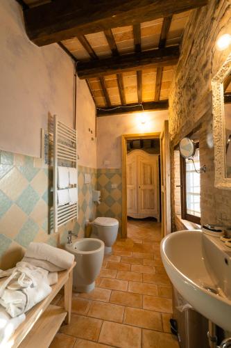 a bathroom with two toilets and a sink and a tub at Ca' Virginia Country House Wellness in Montecalvo in Foglia