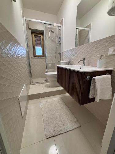a bathroom with a sink and a shower and a toilet at Lucys Home Giardini Naxos in Giardini Naxos