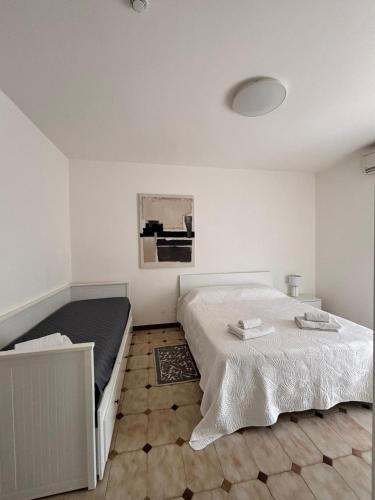 a white bedroom with a bed and a floor at Lucys Home Giardini Naxos in Giardini Naxos