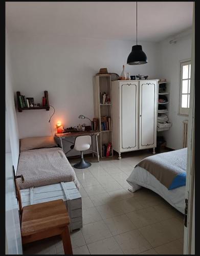 a bedroom with two beds and a desk and a refrigerator at B&B Antica Neviera in Gioia del Colle