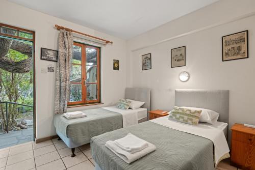 two beds in a room with a window at Antonys Garden House in Episkopi Limassol
