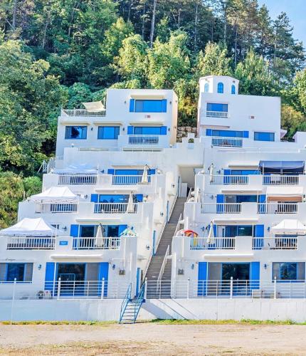 a large white building with blue windows and stairs at Airini Pension in Damyang