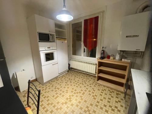 a small kitchen with white appliances and a window at L'appart du Château in Blois