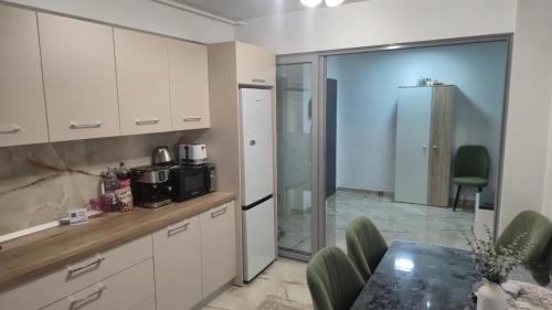 a kitchen with white cabinets and a table at Zanora apartment's in Aiud