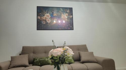 a living room with a couch with flowers on it at Zanora apartment's in Aiud