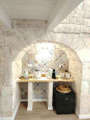 a table in a room with a stone wall at Casa De Amicis 24 in Sammichele di Bari