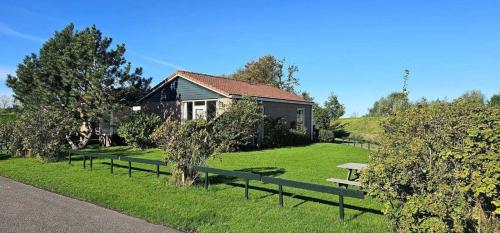 a house with a picnic bench in the grass at Rekerlande 274 in Warmenhuizen