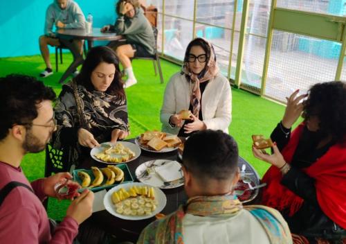 a group of people sitting around a table eating food at Classy5 Guest House in Varanasi