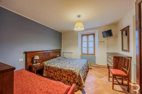 a bedroom with a bed and a table and a chair at Albergo Miramonti in Comano