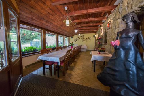 a restaurant with a woman statue in the middle of the room at Penzión Banská Klopačka in Hnilčík