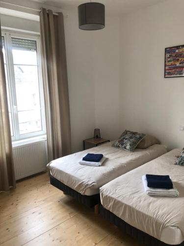 two beds in a room with a window at Villa plaisance in Plomodiern