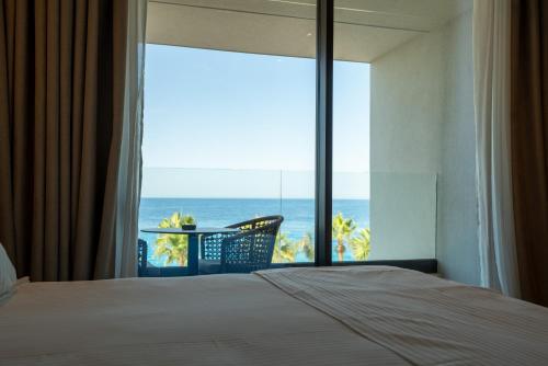 a bedroom with a bed and a view of the ocean at Hotel Morina Palace in Dhërmi