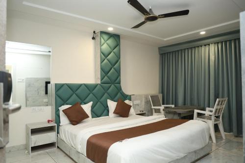 a bedroom with a large bed with a green headboard at Hotel Magnet in Indore