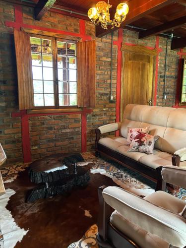 a living room with a couch and a fireplace at Chale do Morro in Marques de Sousa