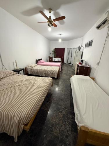 a room with three beds and a ceiling fan at Modo soto in Villa de Soto