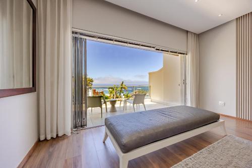 a bedroom with a bed and a large window at Luxury Camps Bay Getaway in Cape Town