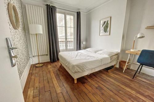 a bedroom with a bed and a desk and a window at Room in elegant and charming 3-bedroom apartment near Bois de Vincennes in Paris