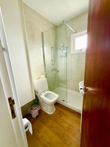 a bathroom with a toilet and a glass shower at Carisa rooms for holiday in Larnaca