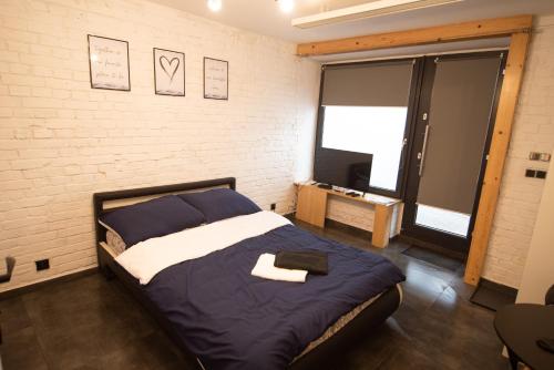 a bedroom with a bed and a brick wall at Dream Loft in Kłodzko