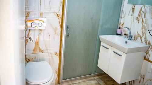 a bathroom with a toilet and a sink and a shower at Zirve Suit Rezidans in Talas