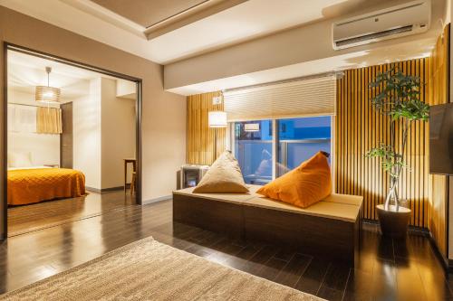 a room with a bed and a couch with pillows at Cozy Stay Sapporo Hongodori in Sapporo
