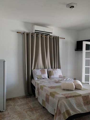 a bedroom with a bed and a window with curtains at Novo Encanto in Ubatuba