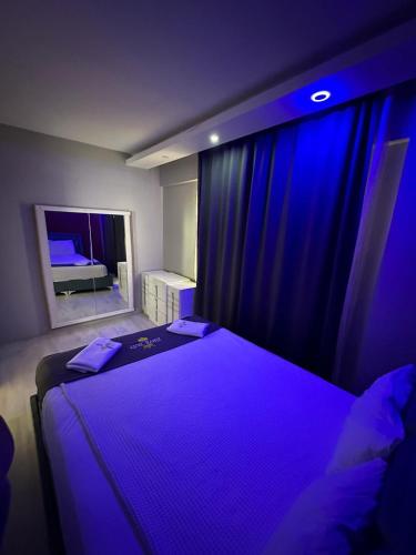 a bedroom with a large bed with purple lighting at Zirve Suit Rezidans in Talas