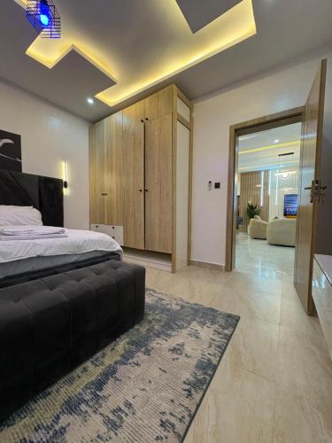 ein Schlafzimmer mit einem großen Bett und ein Wohnzimmer in der Unterkunft 2-Bedroom Apartment with Pool, Gym, Snooker & Table Tennis in Lekki Ajah in Lekki