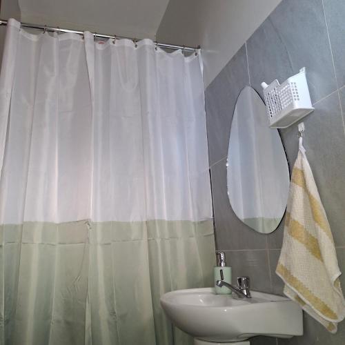 a bathroom with a shower curtain and a sink at Spacious Studio Apartment with Swimming pool in Nairobi