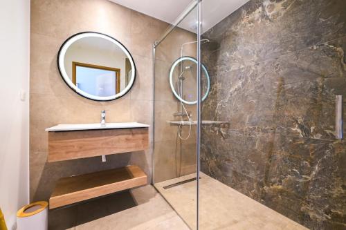 a bathroom with a shower with a sink and a mirror at Villa A Pinnata in Albitreccia