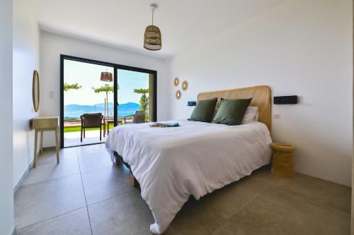a bedroom with a bed with a view of the ocean at Villa A Pinnata in Albitreccia