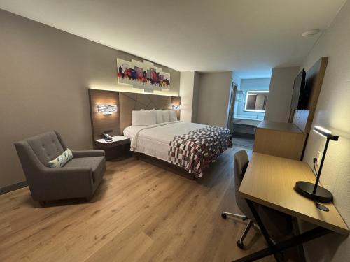 a hotel room with a bed and a chair at Red Roof Inn Arlington - Entertainment District in Arlington